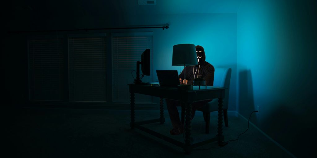 a person sitting at a desk in a dark room
