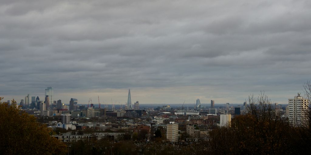 city with high rise buildings under white clouds during daytime