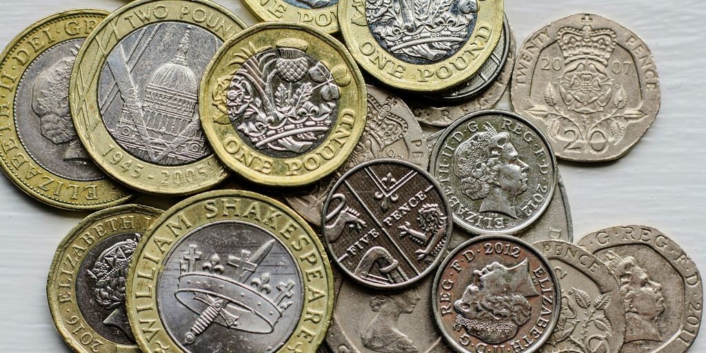a pile of british coins sitting on top of a table