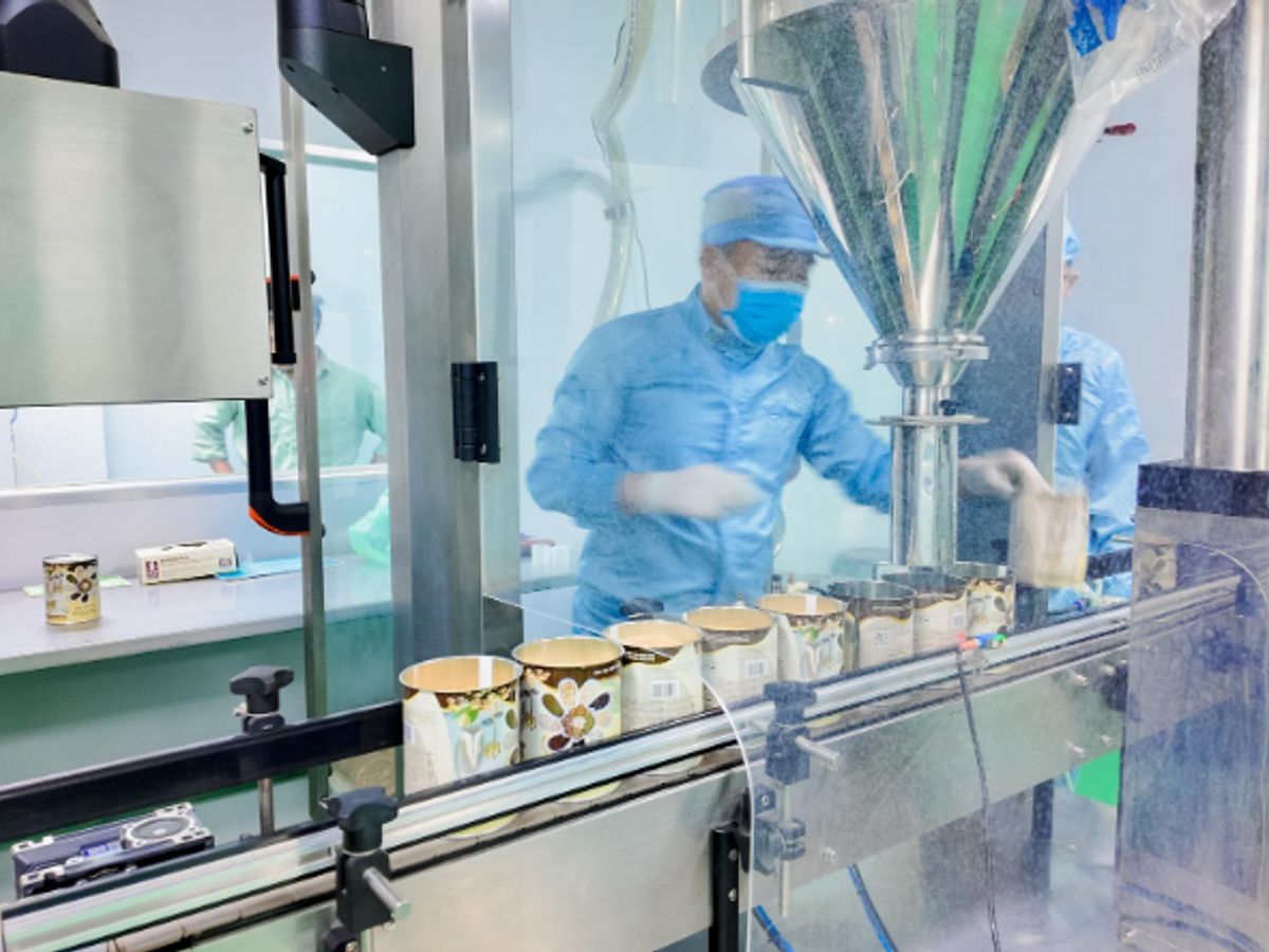 Industrial machine filling containers in a manufacturing environment.