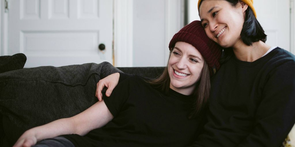 woman in black long sleeve shirt sitting beside woman in red knit cap