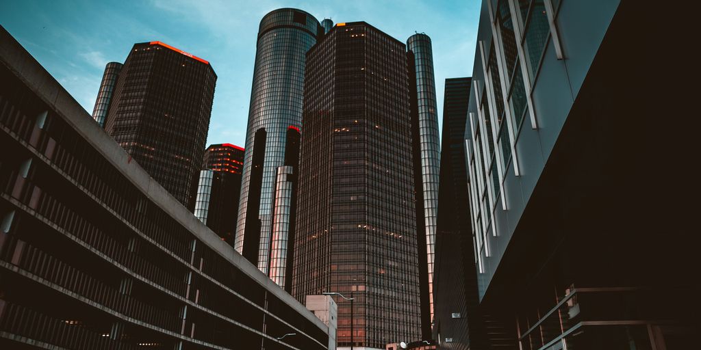 a group of tall buildings with Renaissance Center in the background