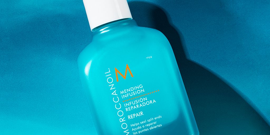 Bottle of Moroccanoil hair treatment on a blue background.