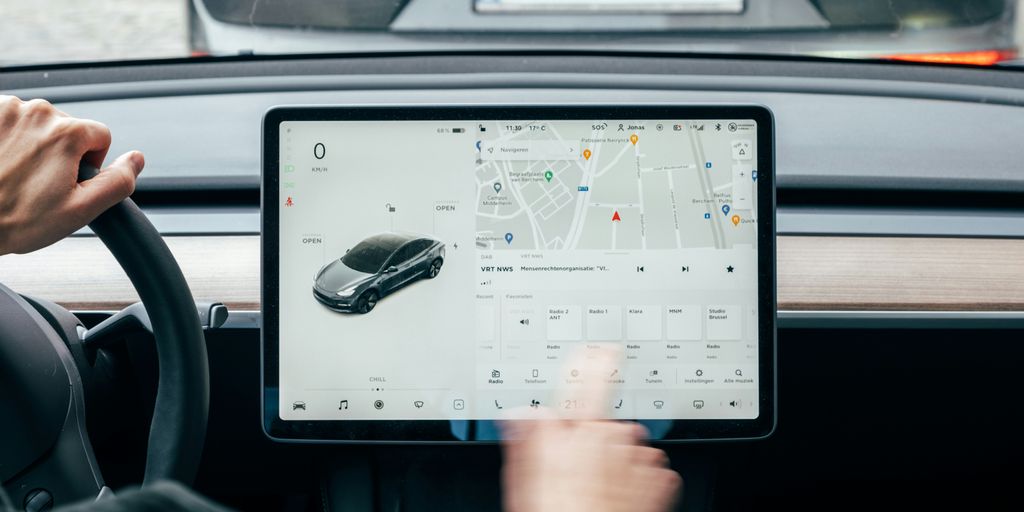 a person driving a car while holding a tablet