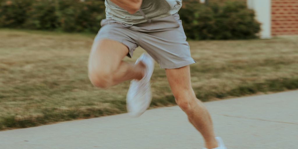 a man in grey shirt and shorts playing a game of tennis