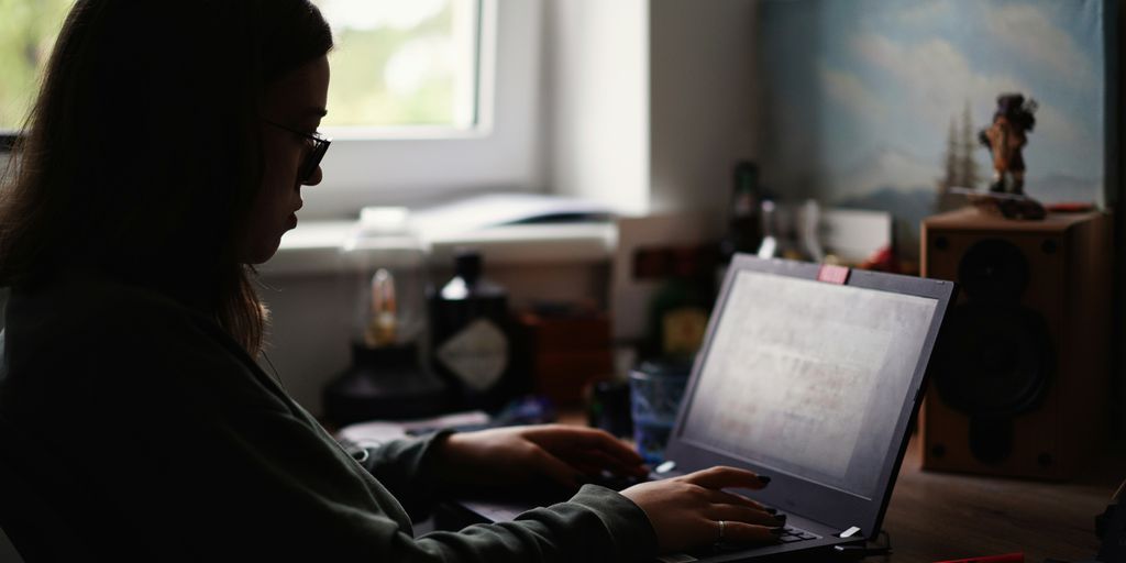 woman in black jacket using macbook pro
