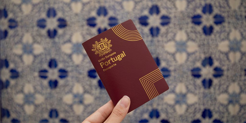 A hand holds a portuguese passport.