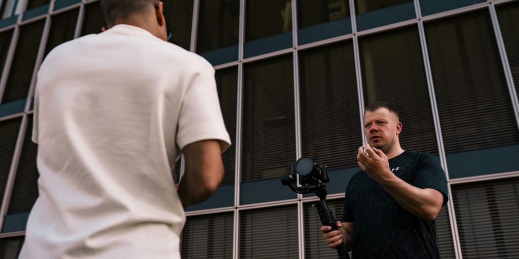 man in white t-shirt standing beside man in black t-shirt