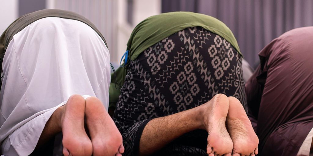 Muslims are praying, bowing down in prayer.
