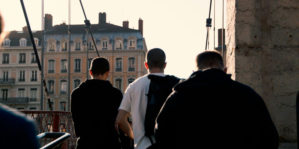 a group of men walking across a bridge