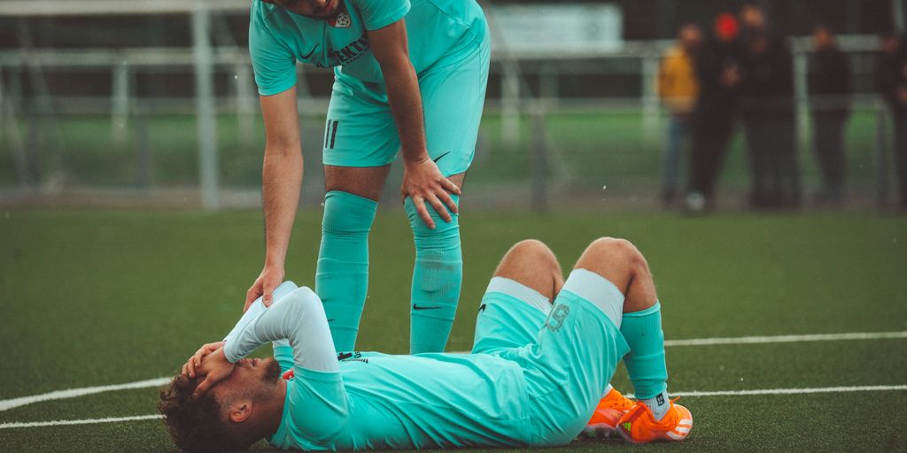 a soccer player is laying on the ground