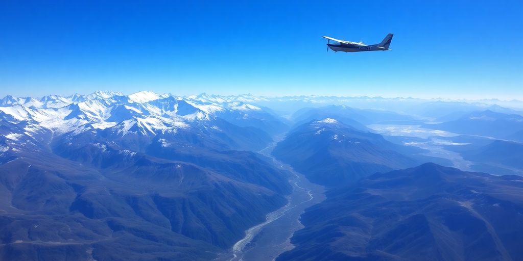 Small airplane flies over vast, snowy Alaskan mountain ranges.