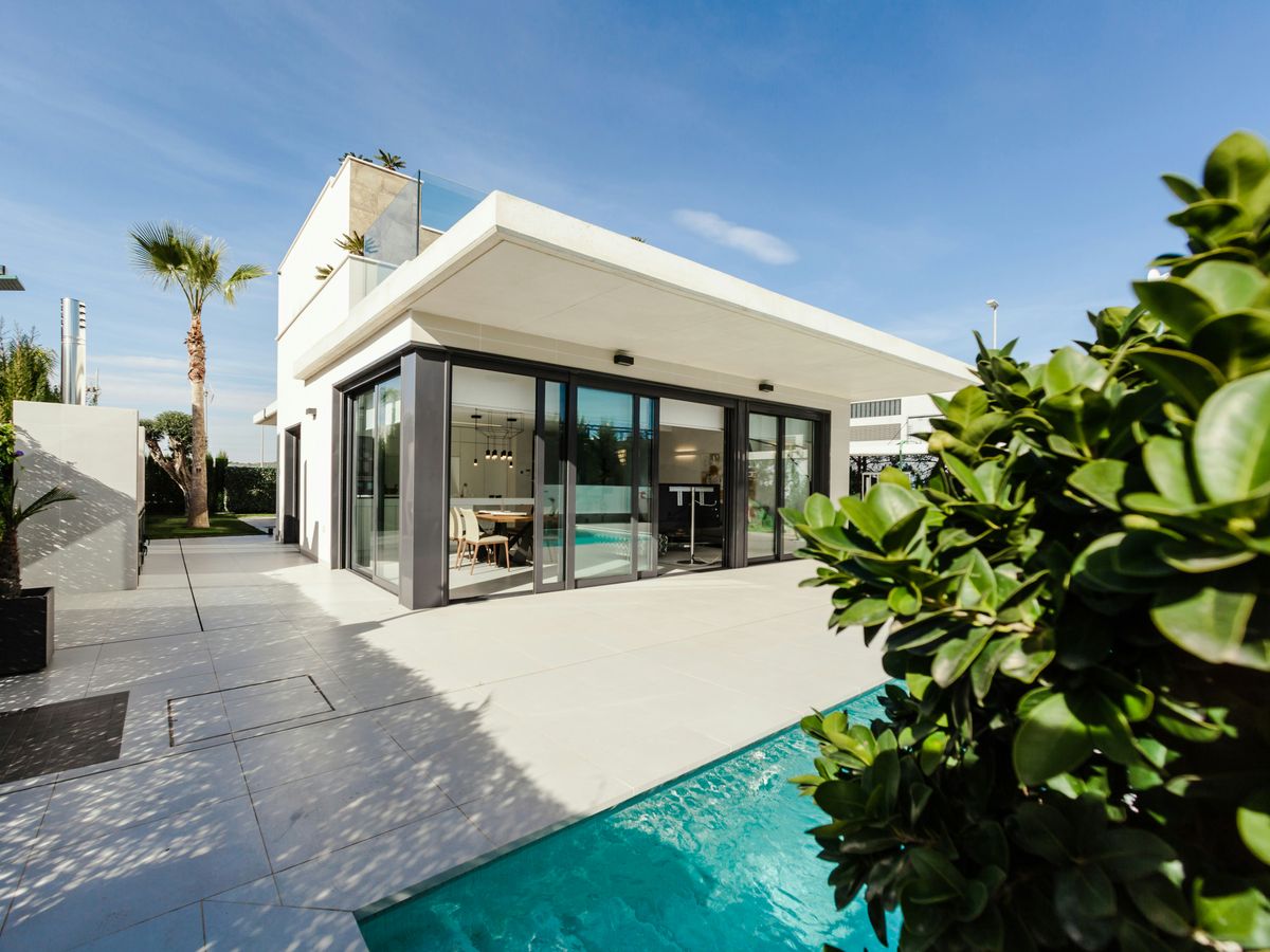 white and grey concrete building near swimming pool under clear sky during daytime