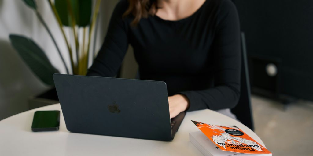 a woman sitting at a table with a laptop