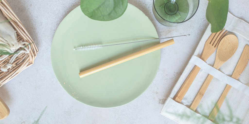 a green plate with a fork, knife, and napkin on it