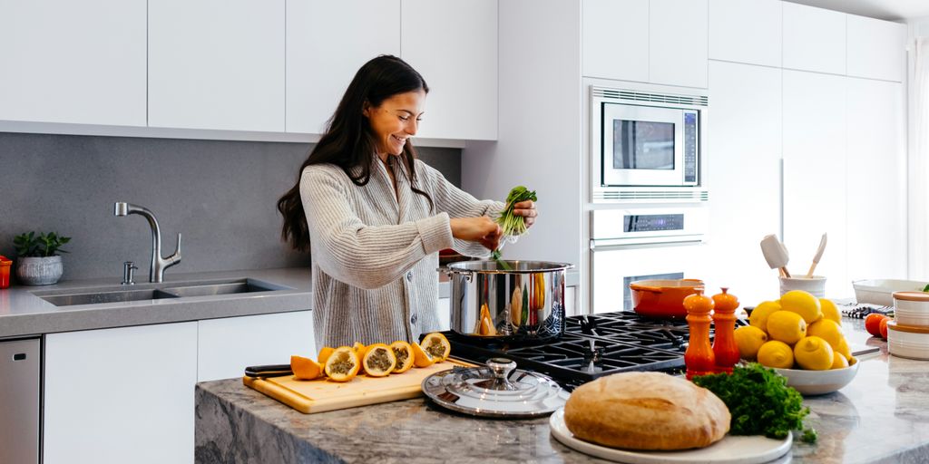 woman smiling while cooking