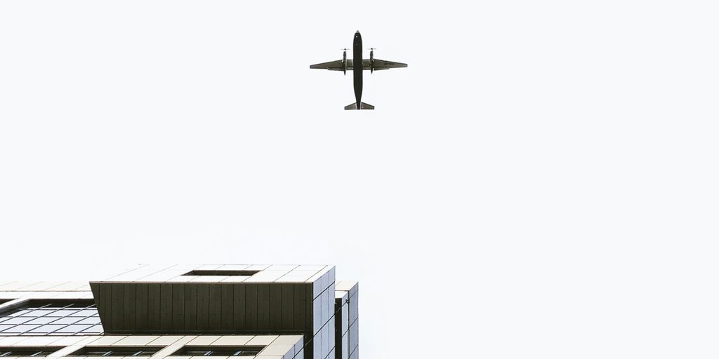 airplane flying over the building