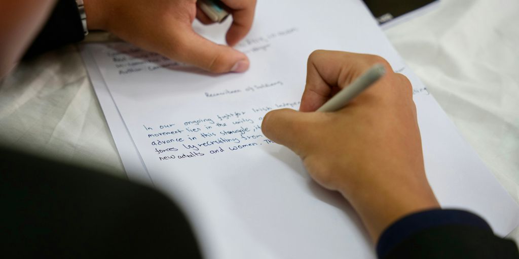 A person writing on a piece of paper