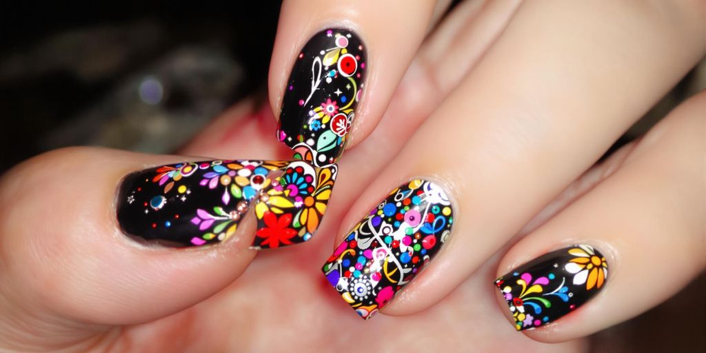 Unhas pretas decoradas com cores vibrantes e padrões.