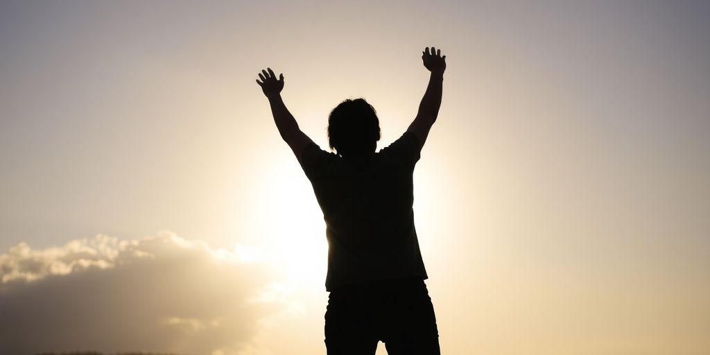 Person reaching for a bright, glowing light.