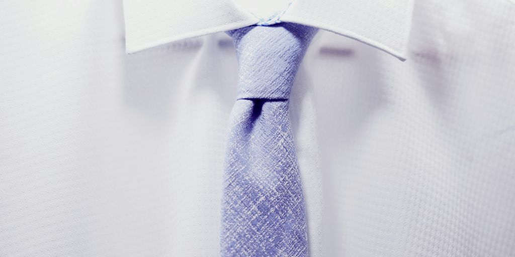 close up photo white collared shirt with blue necktie