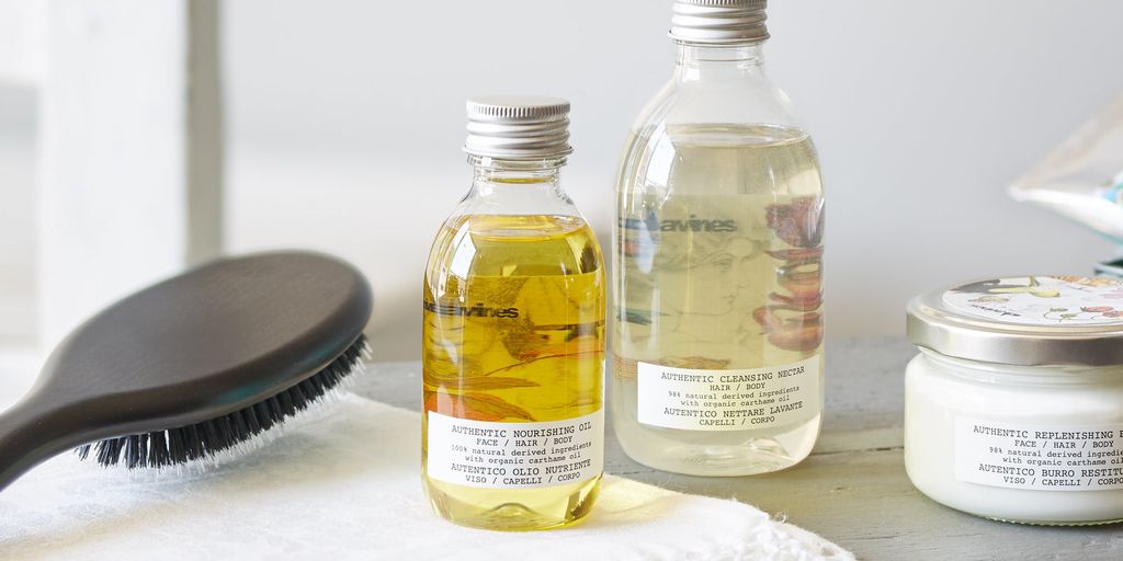 Haircare products and a brush on a white surface.