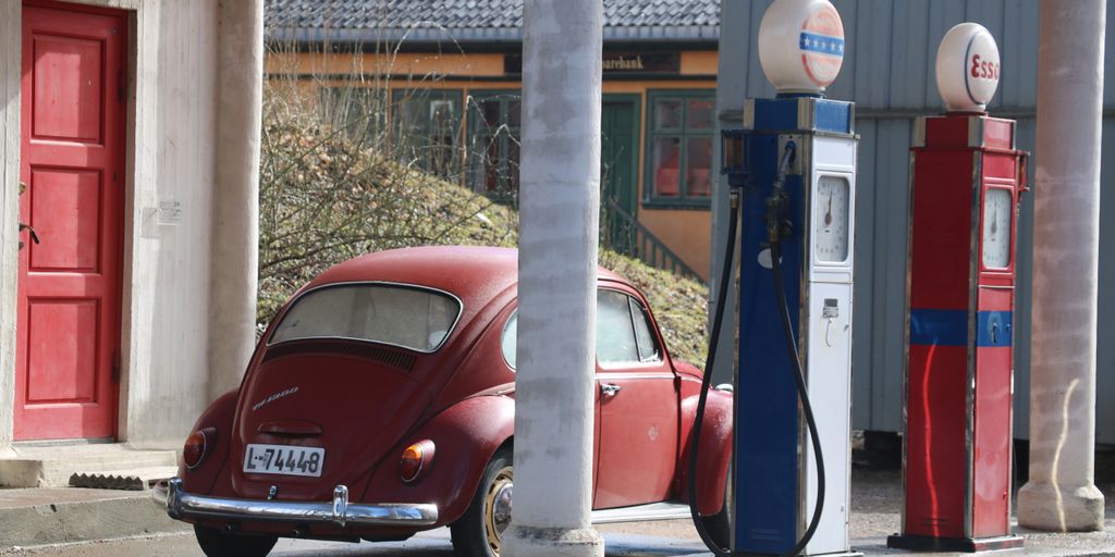 a red car is parked in front of a gas station