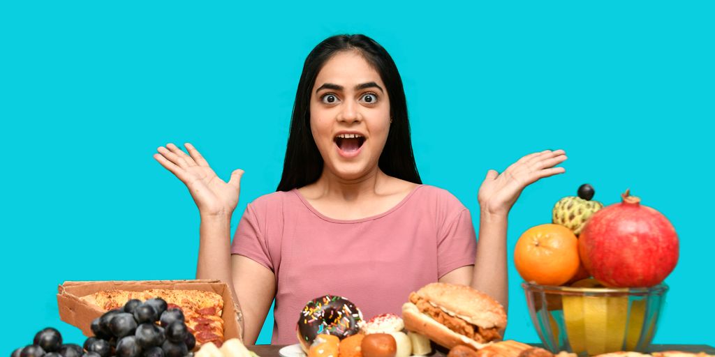 a woman with her mouth open and hands up in front of a table of food
