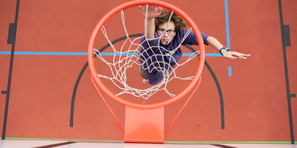 woman in black shirt sitting on basketball hoop
