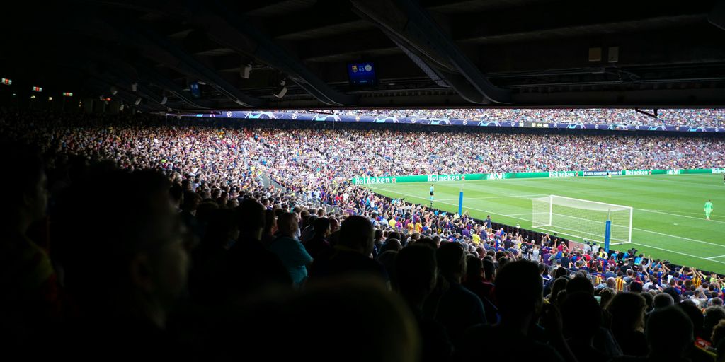 people watching football at stadium during daytime