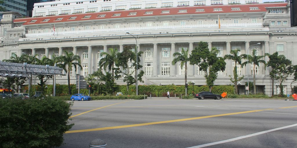 a large white building with palm trees in front of it
