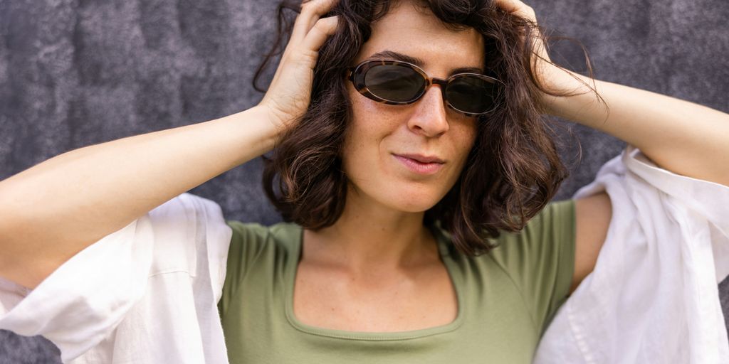 a woman wearing sunglasses and a green shirt
