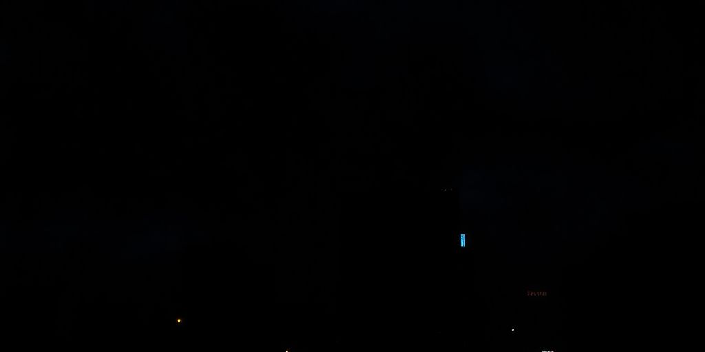 Dark urban skyline at night with dimly lit streets.
