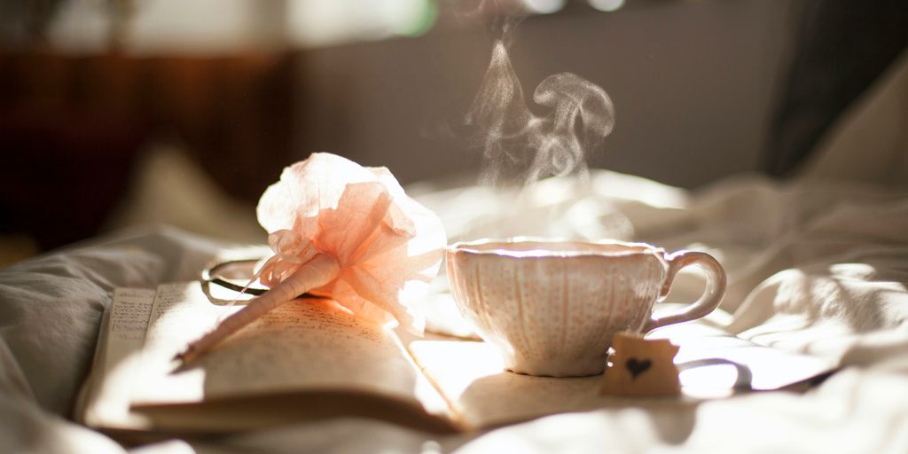 teacup on book beside pink flower decor