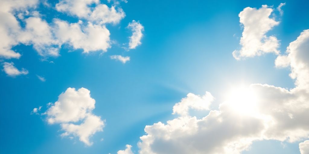 A calm, sunny sky with fluffy clouds.