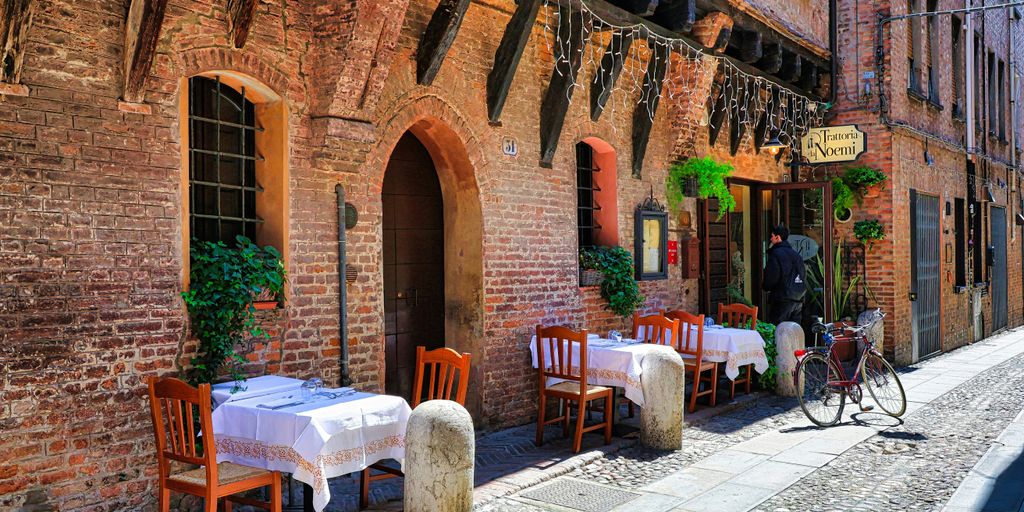 a cobblestone street lined with tables and chairs