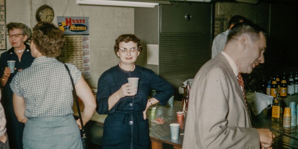 a group of people standing around a bar