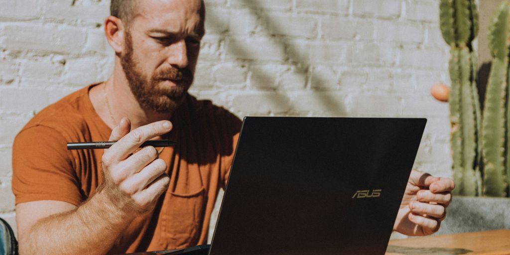 a man sitting at a table using a laptop computer