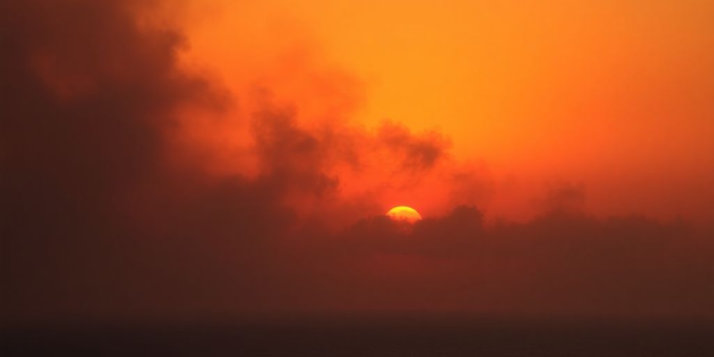 Ciel orangé avec des nuages denses sur la côte.