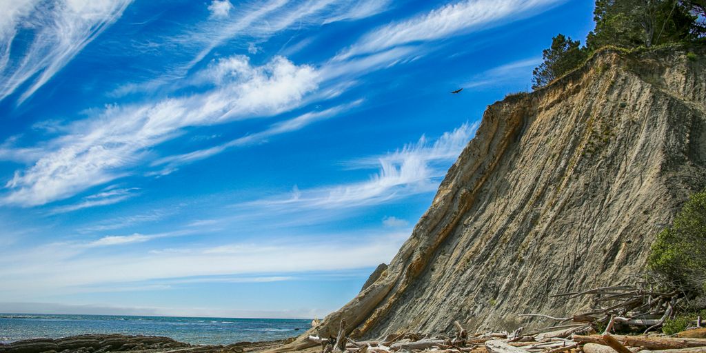 a beach with a cliff and a body of water