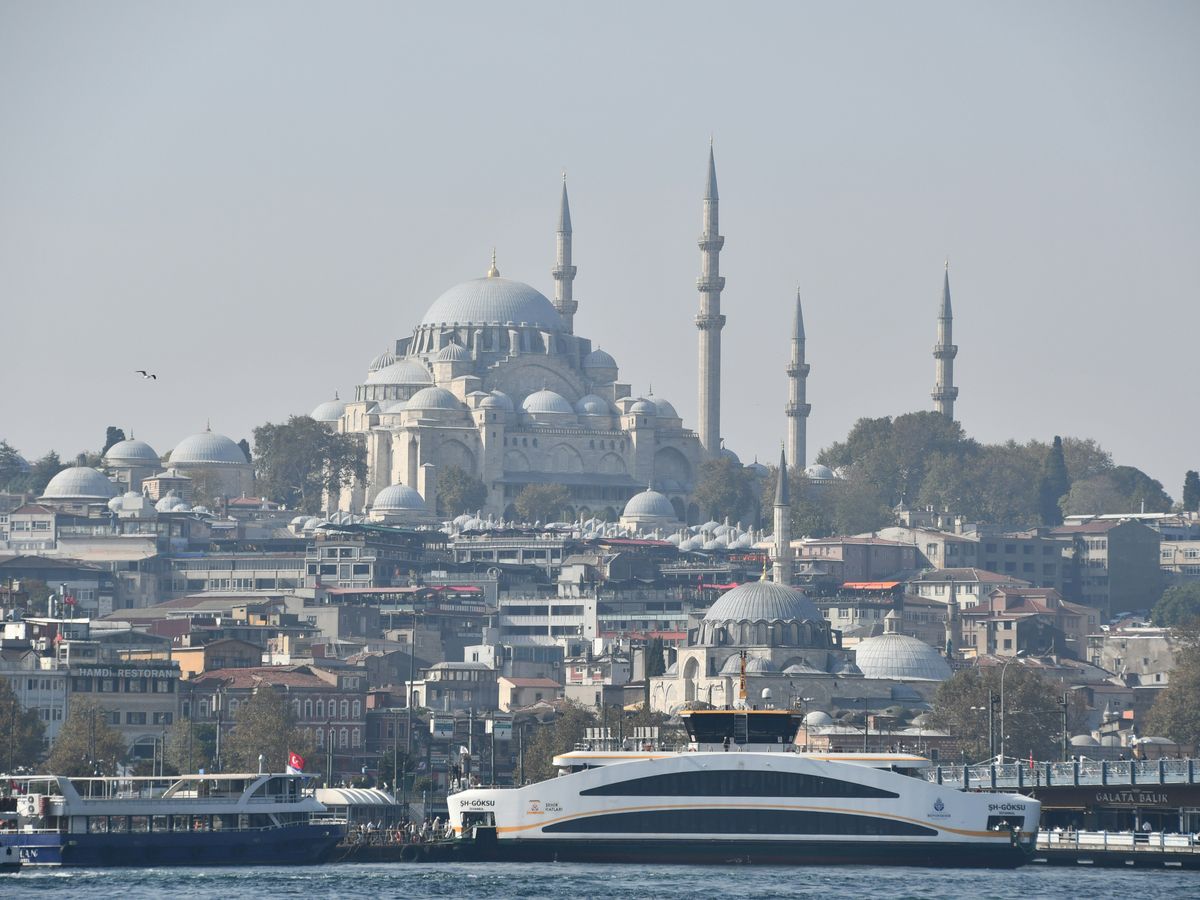 a large boat in the water near a city