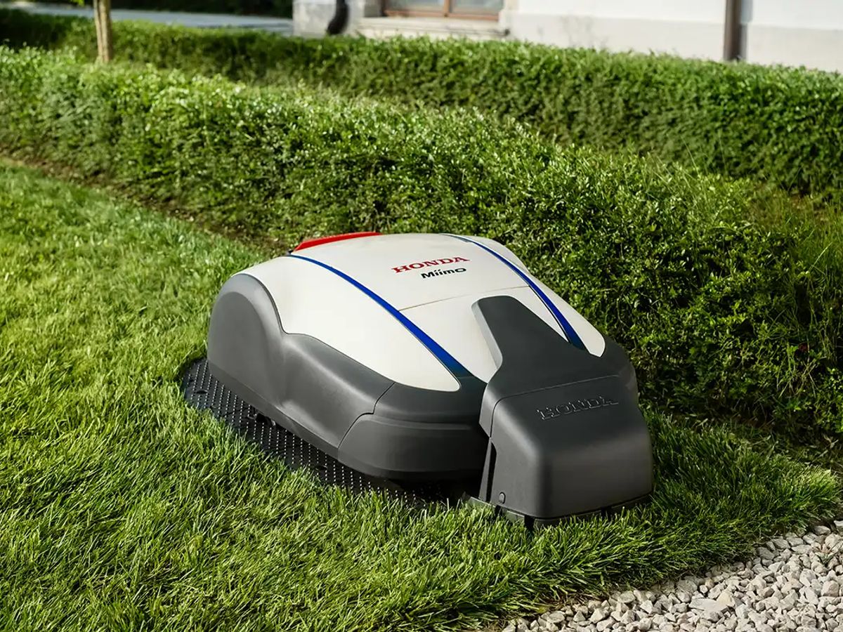 Robotic lawn mower navigating neatly trimmed green grass edges.