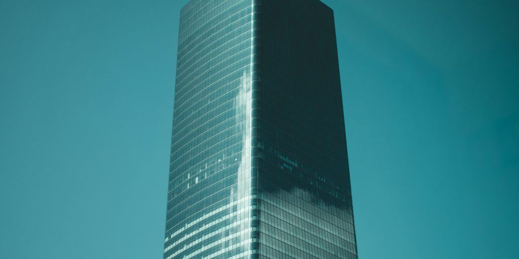 low-angle photography of blue glass high-rise building