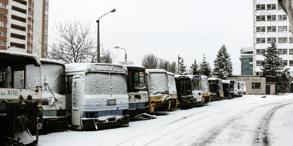 parked abandoned buses near buildings during winter and day