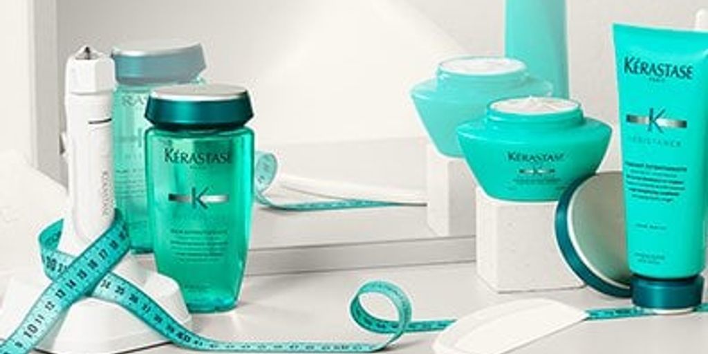 Assorted Kérastase haircare products with a teal measuring tape.