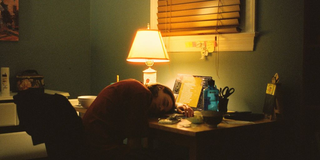 a person sitting at a desk in front of a lamp
