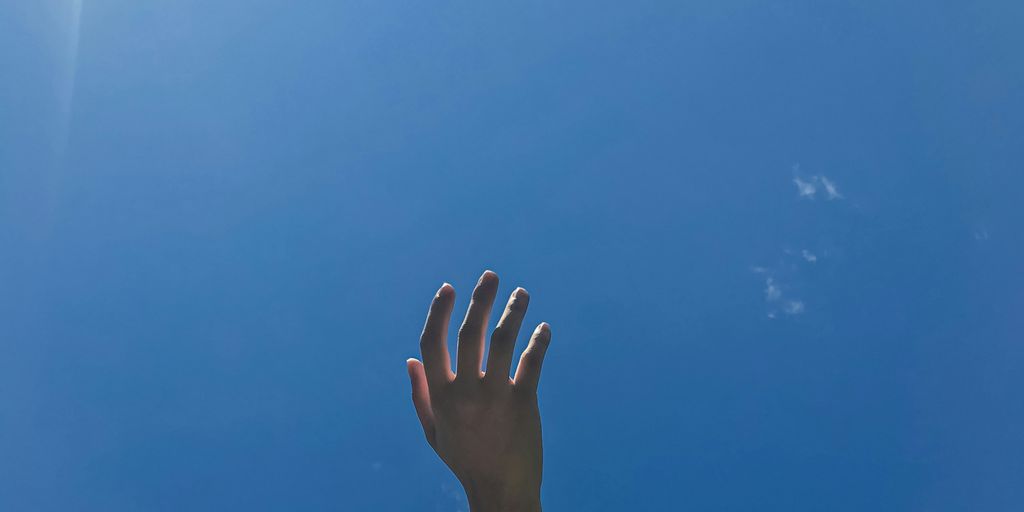 persons left hand with white clouds