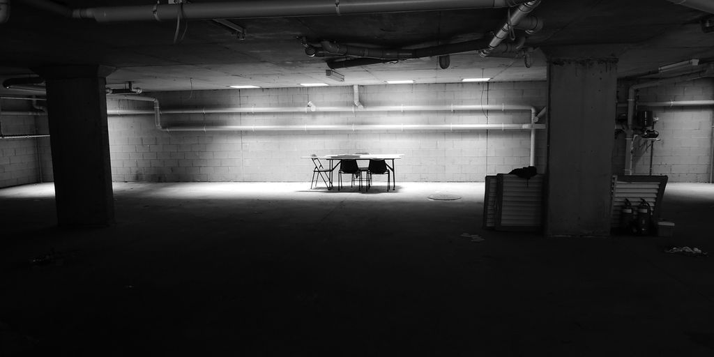 table with chairs near wall in a dark room