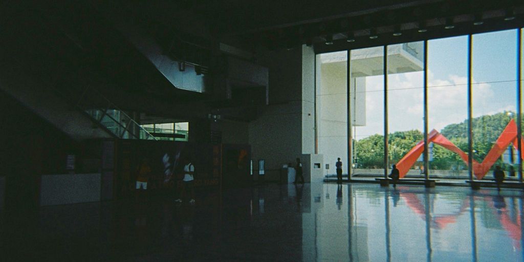 a group of people standing in front of a large window