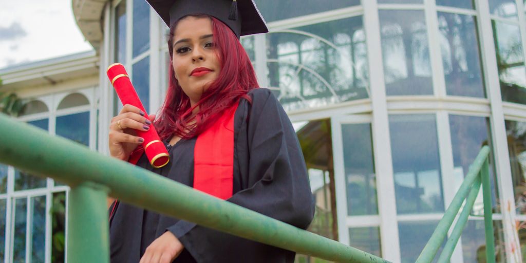 woman in academic gown holding red rose